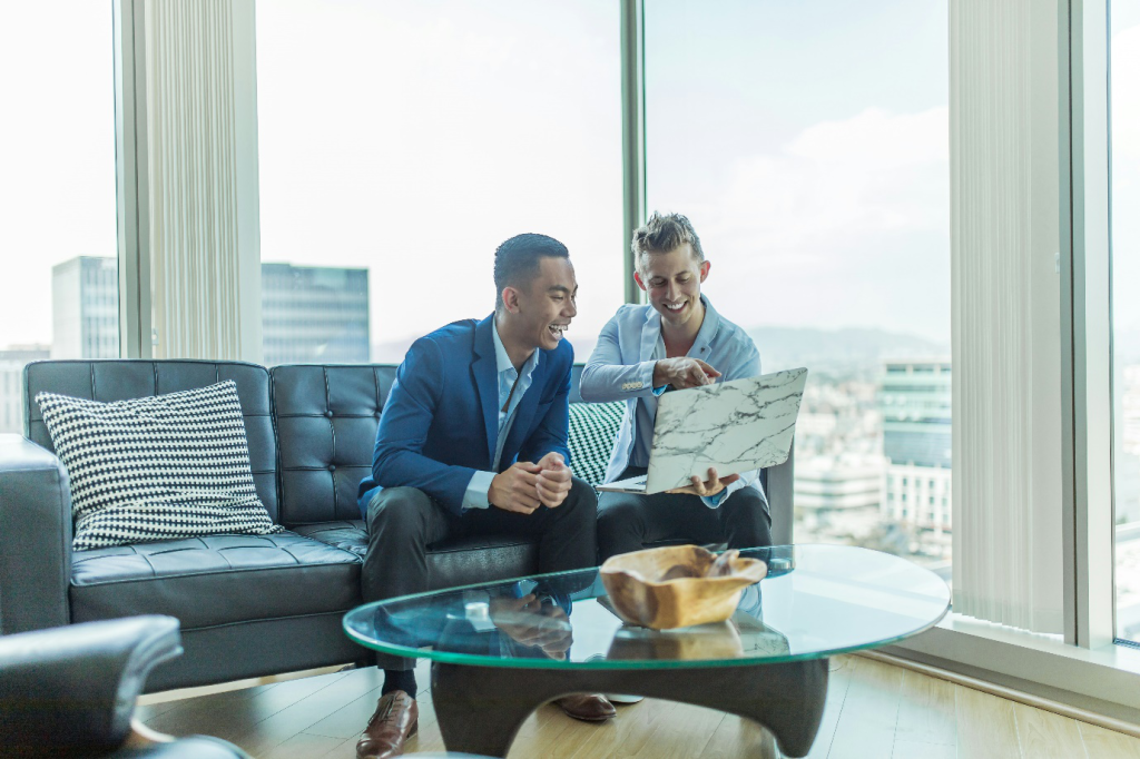 two men in suits sitting on a sofa