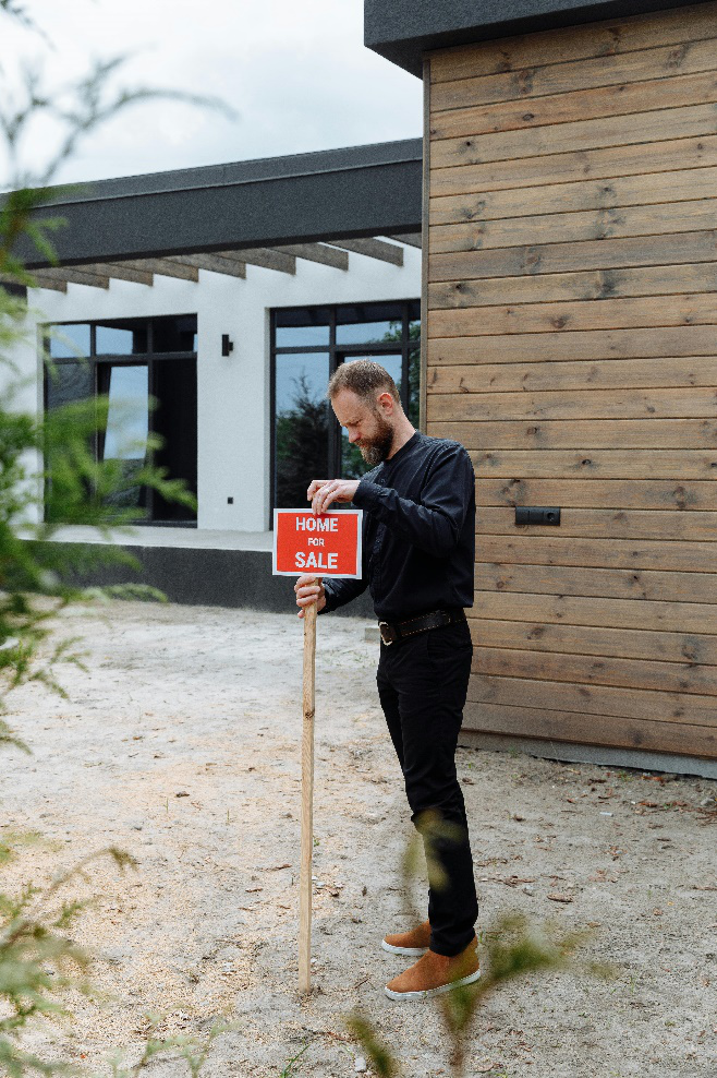 an agent putting a signage outside a house