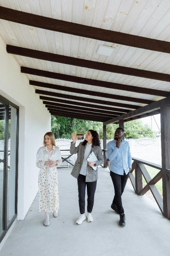 a couple with real estate agent on porch