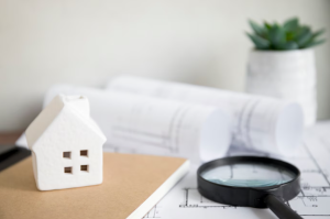 a house and notebook near magnifying glass