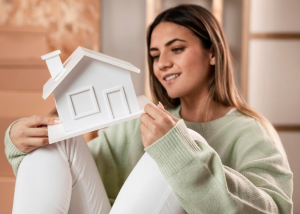 a woman holding a small house